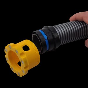 May include: A yellow hose connector with the word "HOSESON" printed on it, featuring magnets around its edge. It's designed to connect to a black and grey corrugated hose, with a blue ring visible. The hose is held by a hand.