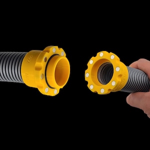 May include: Two sections of a corrugated hose with yellow connectors. The connectors have a circular design with white dots and are labelled. One section is held by a hand against a black background.
