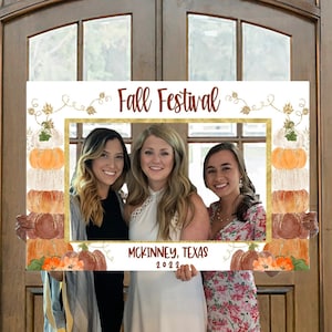 May include: A white photo booth frame with a gold border and a fall festival theme. The frame has a watercolor design of pumpkins, leaves, and vines. The text "Fall Festival" is written in gold lettering at the top of the frame. The text "McKinney, Texas 2022" is written in black lettering at the bottom of the frame.