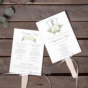 May include: Two white wedding fans with floral designs and white ribbon. The left fan lists the wedding party and special thanks. The right fan says "Welcome to the wedding of Megan and Ryan The 17th of June, 2019" and lists the ceremony order.