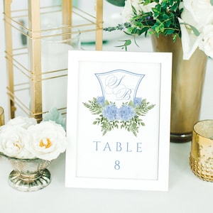 May include: White table number card with a blue and green floral design and the text "TABLE 8".