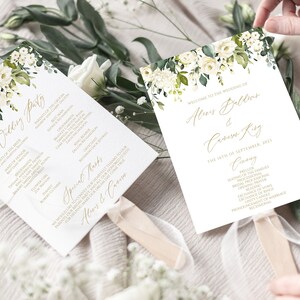 Può includere: Ventagli per il programma della cerimonia di matrimonio con fiori bianchi e foglie verdi. I ventagli presentano il testo "Benvenuti al matrimonio di Alice Ballinger & Cavern King, Il 17 settembre 2021, Cerimonia".