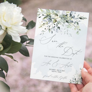 May include: Save the Date card with a watercolor floral design in shades of green and gold. The card features the text "Save the Date" in a script font and the names "An & Aiste" with the date "Saturday, May 9, 2020" and location "Austin, Texas".