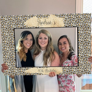 May include: A photo booth prop with a leopard print background and gold glitter accents. The text "Andrea's 40th Birthday" is printed on the bottom of the frame.