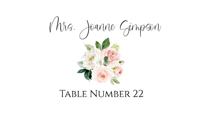 May include: A white card with black text that reads "Mrs. Joanne Simpson" and "Table Number 22". A watercolor illustration of a bouquet of white and pink flowers with green leaves is centered on the card.