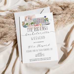 May include: A white card with black text announcing a bachelorette weekend in New Orleans, Louisiana. The card features a watercolor illustration of a cityscape with a steamboat, a saxophone, and a building with a fleur-de-lis. The text reads "The Big Easy Bachelorette Weekend Let's Celebrate Allie Shepard Friday, May 18 thru Sunday 22.  Address Garden District New Orleans, LA RSVP to Ashley by June 1 at 504-473-9993 See Itinerary for Additional Details"