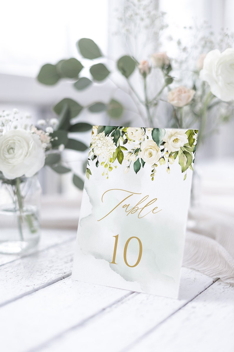May include: White floral table number card with gold calligraphy that says "Table 10" on a light green watercolor background.