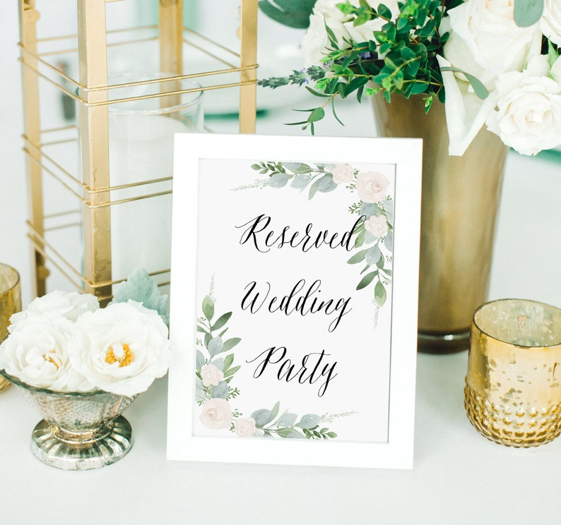 K&ouml;nnte beinhalten: Ein wei&szlig; gerahmtes Schild mit einem floralen Design und dem Text "Reserved Wedding Party" in schwarzer Kalligraphie.