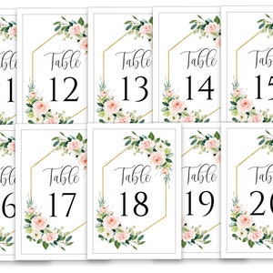 Puede incluir: Diez tarjetas de n&uacute;mero de mesa blancas con marcos geom&eacute;tricos dorados y dise&ntilde;os florales. Los n&uacute;meros van del 11 al 20.