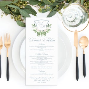 May include: A wedding dinner menu with a blue and white crest design. The menu lists the appetizers, main course, dessert, and a thank you message for Abigail & Ryan. The date is May 25, 2019.