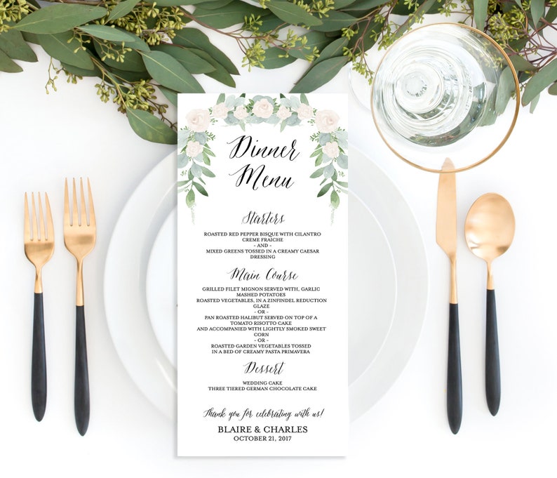 May include: A white wedding menu card with a floral design. The menu includes starters, main course, and dessert options. The card also includes the names of the couple, Blaire & Charles, and the date of the wedding, October 21, 2017.