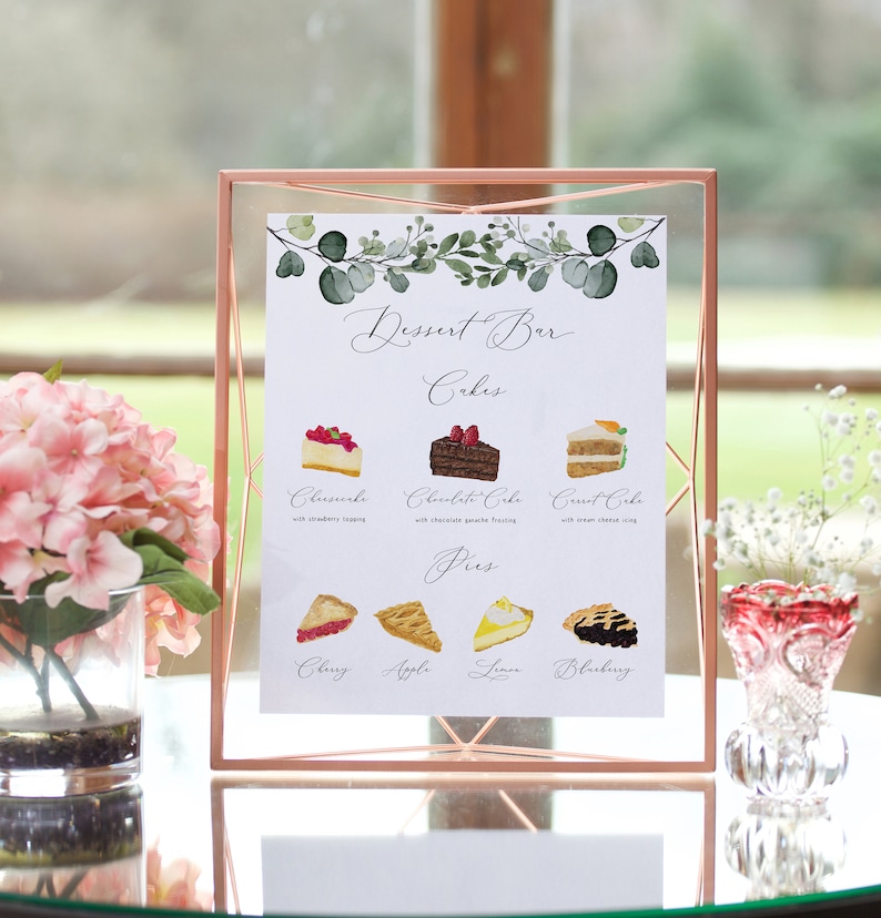 May include: A white sign with a gold frame lists the dessert bar options: cakes and pies. The cakes are cheesecake, chocolate cake, and carrot cake. The pies are cherry, apple, lemon, and blueberry.