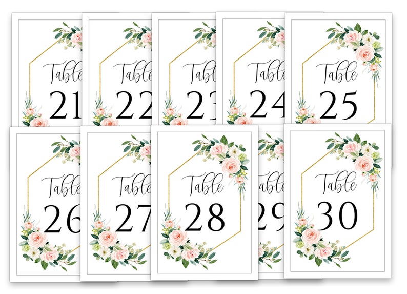 Puede incluir: Diez tarjetas de n&uacute;mero de mesa blancas con marcos geom&eacute;tricos dorados y dise&ntilde;os florales. Los n&uacute;meros van del 21 al 30.
