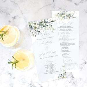 May include: A wedding ceremony program with a watercolor floral design in shades of green and blue. The program includes the names of the bride and groom, the wedding date, and the order of events. The text "Welcome to the Wedding of" is at the top of the program.