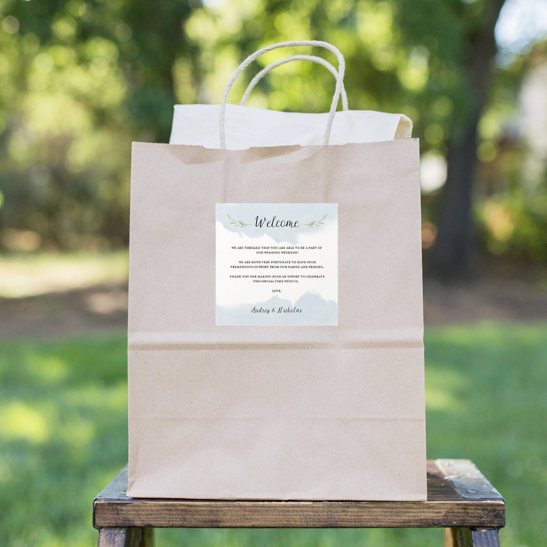 K&ouml;nnte beinhalten: Eine braune Papiert&uuml;te mit einer Willkommensnachricht f&uuml;r eine Hochzeit. Die Nachricht lautet: "Willkommen, Wir freuen uns sehr, dass Sie Teil unseres Hochzeitswochenendes sein k&ouml;nnen. Wir sind beide sehr gl&uuml;cklich, Ihre gro&szlig;artige Unterst&uuml;tzung von unserer Familie und unseren Freunden zu haben. Vielen Dank, dass Sie sich die Zeit nehmen, um mit uns zu feiern. Audrey & Michaels"