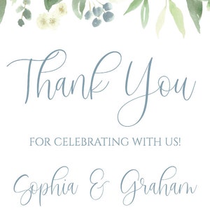 May include: A white thank you card with blue text. The text reads "Thank You" and "For celebrating with us!"  "Sophia & Graham" and "May 25, 2019". The card is decorated with a watercolor floral border of white and blue flowers and green leaves.