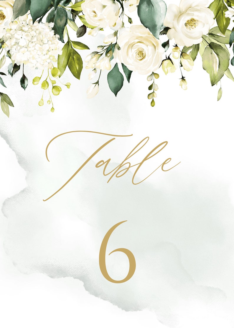 May include: White floral wedding table number card with green leaves and a gold background. The card says "Table 6".