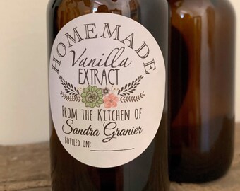 May include: Two brown glass bottles of homemade vanilla extract. The bottles have black caps and are tied with twine. The label reads "Homemade Vanilla Extract From The Kitchen of Sandra Granier".
