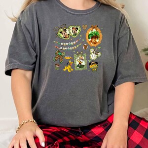 A woman wearing a gray t-shirt with a graphic design and red plaid pajama bottoms.