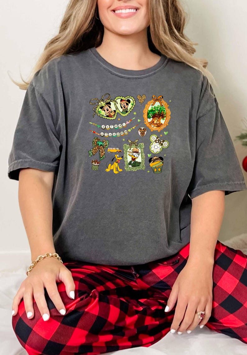 A woman wearing a gray t-shirt with a graphic design and red plaid pajama bottoms.