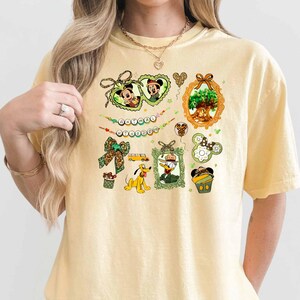 A woman wearing a yellow t-shirt with various Disney-themed illustrations and text.