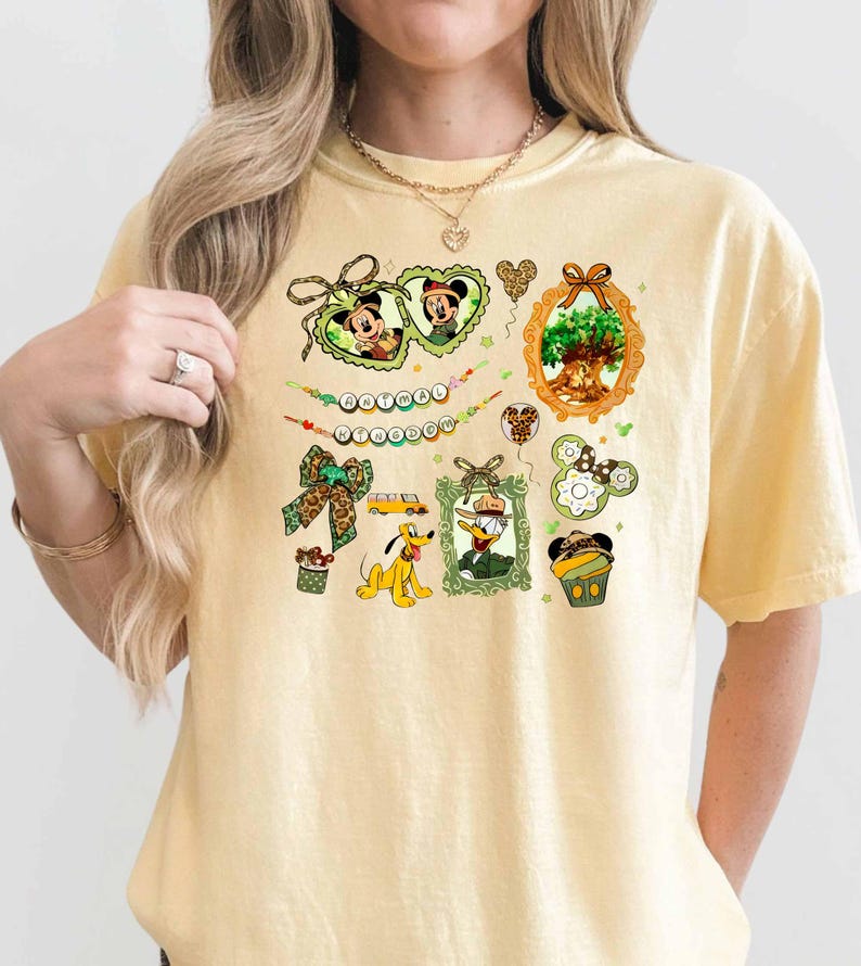 A woman wearing a yellow t-shirt with various Disney-themed illustrations and text.