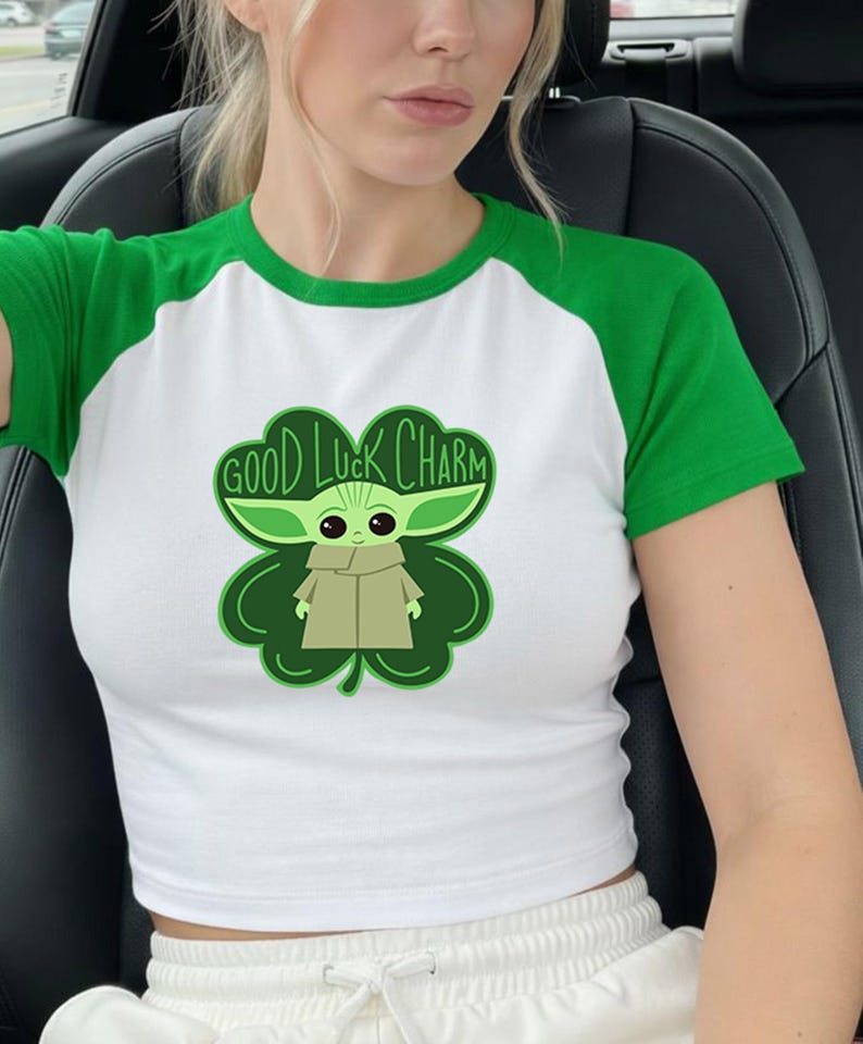 A woman wearing a green and white t-shirt with a cartoon character and text printed on it.
