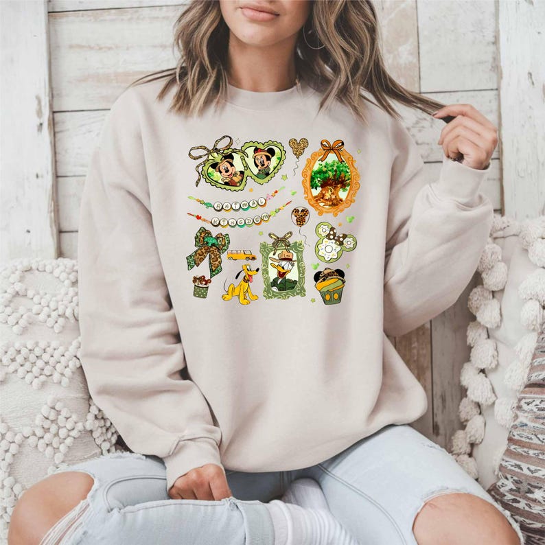 A woman wearing a beige sweater with a colorful graphic design featuring various Disney characters and elements.