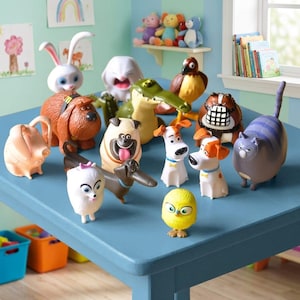 Könnte beinhalten: Eine Sammlung von Kunststoff-Tierfiguren aus Pets, darunter ein weißer Hase, ein brauner Hund, ein Mops, ein Dackel, ein Krokodil, ein Falke, ein weißer Terrier, ein Beagle, eine graue Katze und ein gelbes Küken auf einem blauen Tisch.