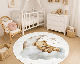 May include: A round nursery rug featuring a sleeping teddy bear on a crescent moon and clouds. The rug has a white background with star accents. The design is soft and inviting, perfect for a baby's room.
