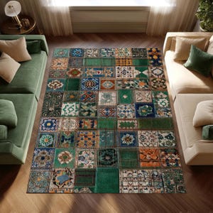 May include: A rectangular area rug with a patchwork design. The rug features a variety of square and rectangular patterns in shades of green, blue, orange, and beige. The rug is placed on a wooden floor, with green and beige sofas on either side.