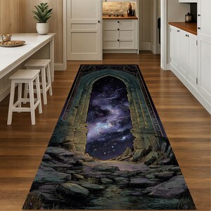 Puede incluir: Una alfombra rectangular con una ilustración detallada de un arco que se abre a un cielo estrellado. El arco es de piedra y la alfombra tiene un borde oscuro. La paleta de colores incluye azules, grises y verdes.