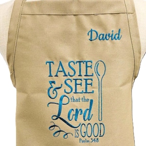 May include: A tan kitchen apron with the text "Taste & See that the Lord is Good Psalm 34:8" embroidered in blue. The name "David" is embroidered in blue in the top right corner.