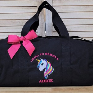 May include: Black canvas duffel bag with a pink bow, embroidered with a rainbow unicorn and the text "GOING TO MAMMY'S ADDIE".