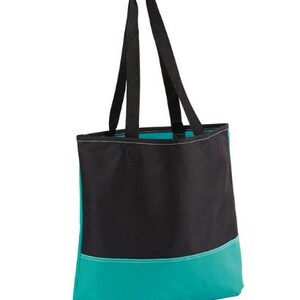 Puede incluir: Una bolsa de mano negra y turquesa con dos asas negras. La bolsa tiene una secci&oacute;n superior negra y una secci&oacute;n inferior turquesa.