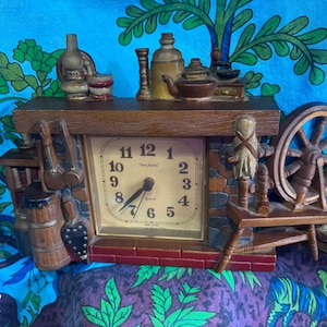 1970's New Haven Burwood Hard Plastic Clock Colonial Fireplace Spinning Wheel