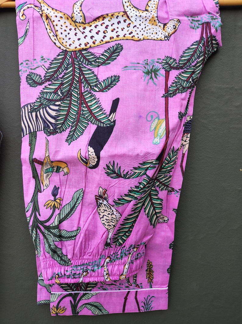 Puede incluir: Pantal&oacute;n de pijama rosa con un estampado de jungla vibrante que presenta un leopardo, una cebra, un tuc&aacute;n y otras aves y follaje tropicales. El pantal&oacute;n tiene un ribete blanco y una cintura el&aacute;stica. La tela es suave y ligera.