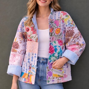 Può includere: Giacca patchwork con motivo floreale nei toni del rosa, giallo e viola. La giacca ha un bordo a righe azzurre sui polsini e sul colletto. Presenta una vestibilità ampia e due tasche anteriori.