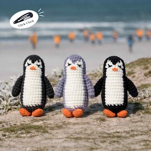 May include: Three handmade crochet penguins with black, white, and gray bodies, orange feet, and closed eyes. The penguins are standing on a sandy surface with a blurred ocean background. The text "Click-Clack" is in the upper left corner.