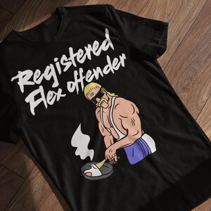 May include: Black t-shirt with the text "Registered Flex Offender" in white. The shirt features a cartoon illustration of a muscular man cooking in a pan. The man has blonde hair, sunglasses, and a mustache.