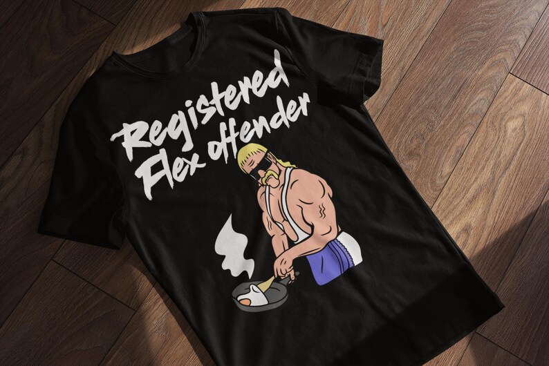 May include: Black t-shirt with the text "Registered Flex Offender" in white. The shirt features a cartoon illustration of a muscular man cooking in a pan. The man has blonde hair, sunglasses, and a mustache.