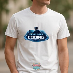 Pode incluir: Camiseta branca com um gr&aacute;fico azul e branco de uma pessoa com fones de ouvido trabalhando em um computador. O gr&aacute;fico inclui as palavras "DEVELOPER CODING" em um design azul e branco. A camisa tamb&eacute;m tem um pequeno logotipo.