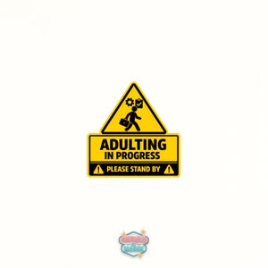 May include: A yellow and black sign with the text "ADULTING IN PROGRESS" and "PLEASE STAND BY". The sign features a graphic of a person carrying a briefcase and a gear symbol. The sign is a humorous take on the challenges of adulthood.