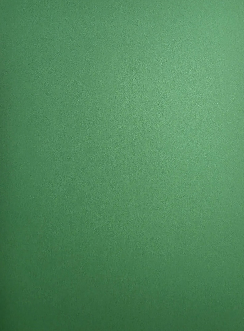 May include: A solid, flat, and uniform surface featuring a vibrant, medium-toned green color. The texture appears smooth with a subtle, consistent grain throughout, providing a clean and minimalist appearance across the entire visible frame.