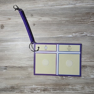 Puede incluir: Un tablero de comunicaci&oacute;n con un borde morado y un cord&oacute;n en espiral morado. El tablero tiene dos secciones con las palabras "Ahora" y "Siguiente" y un recorte circular en cada secci&oacute;n. Un icono de reloj est&aacute; en la secci&oacute;n "Ahora".