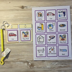 May include: A visual schedule set featuring a yellow coiled lanyard with a clip, a small rectangular card with 'Car' and 'Play Park' icons, and a larger sheet with twelve purple-bordered squares showing daily activities like Home, Car, Swimming, Breakfast, Lunch, Dinner, School, Brush Teeth, Play Park, Bath, Get Dressed, and Bed.