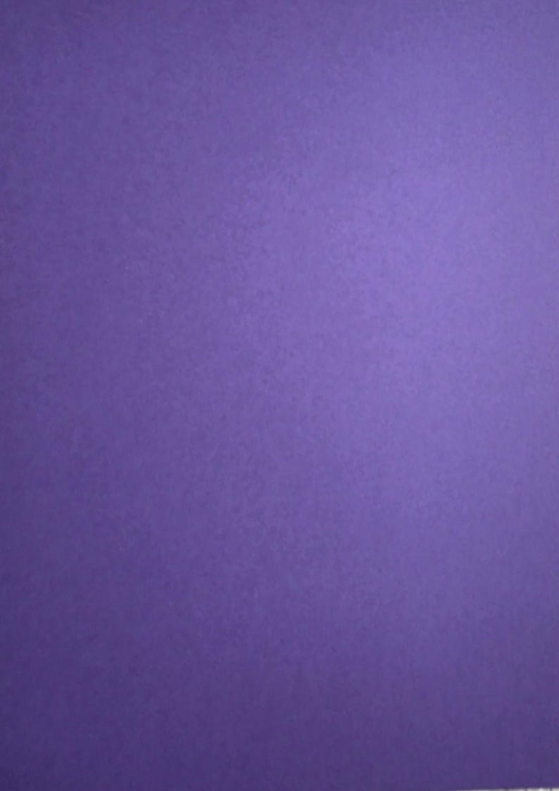 May include: A solid sheet of paper with a vibrant purple color and a smooth, matte texture. The surface is uniform in tone, displaying a consistent deep violet hue across the entire rectangular area, providing a clean and simple visual background.