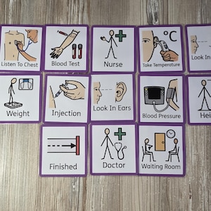 May include: A collection of twelve square cards with purple borders, each displaying a medical illustration and text. The cards show actions such as "Listen to Chest," "Blood Test," and "Take Temperature." The cards are arranged on a wooden surface.