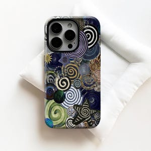 May include: A phone case with a vibrant abstract pattern of spirals, stars, and sunbursts in blue, green, gold, and black. The case has a glossy finish and a camera cutout.