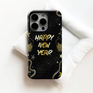 May include: Black phone case with a gold glitter design and the words "HAPPY NEW YEAR" in gold script. The case features gold stars, champagne glasses, and a starry background.